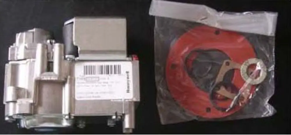 Gasmagnetventil von Remeha, Metallkonstruktion auf der linken Seite, rechts ein in Folie verpackter runder Dichtungsring mit Montagezubehör.